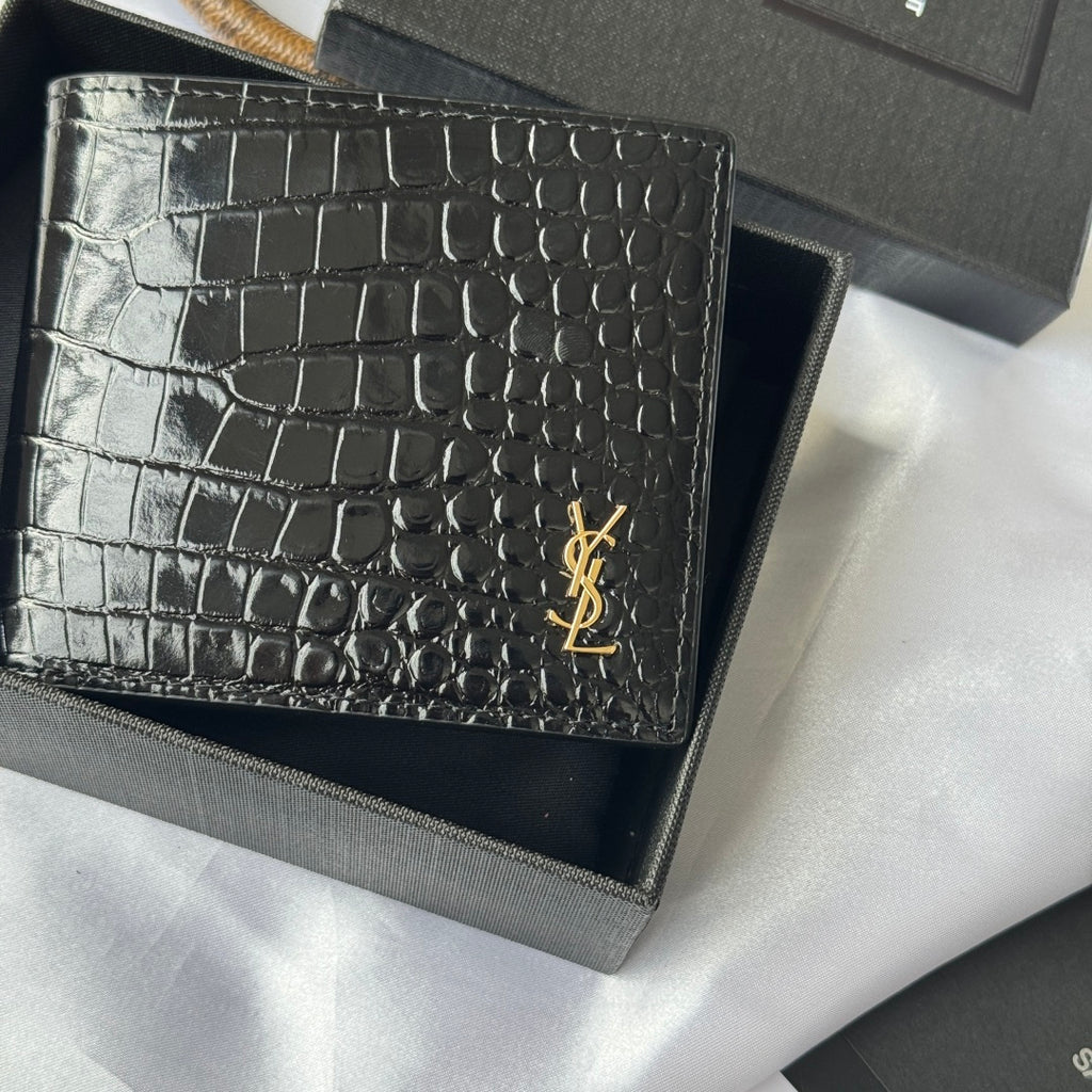 Small crocodile-embossed leather card case with gold YSL logo, close-up