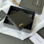 Small bag wallet with dark exterior, stitched border, and gold YSL-style emblem
