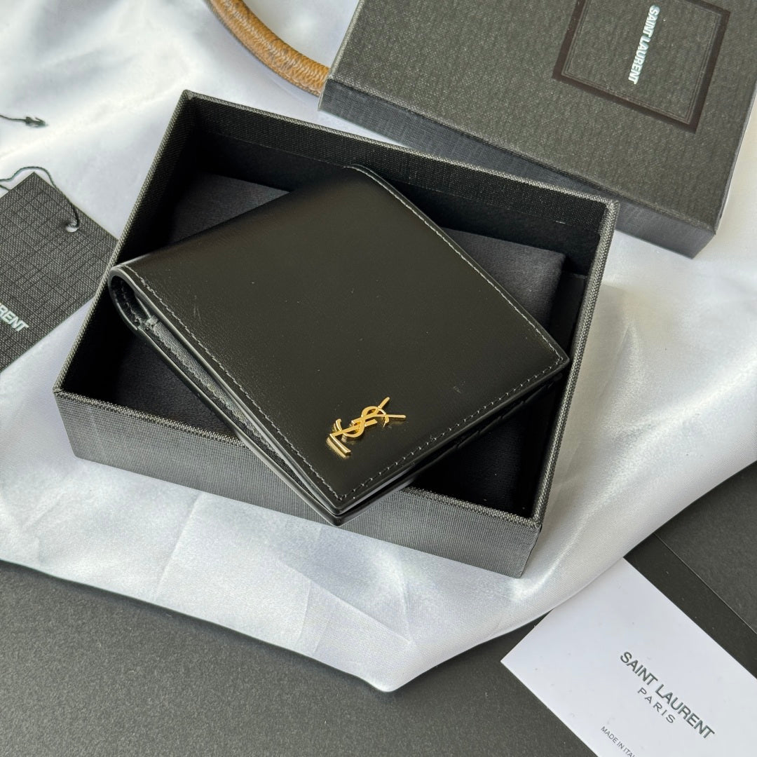 Small bag wallet with dark exterior, stitched border, and gold YSL-style emblem