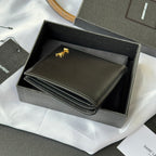 Small bag wallet open, showing layered card compartments with gold logo detail