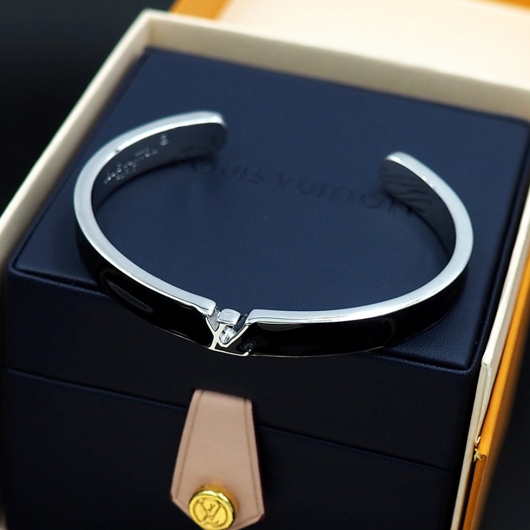 Louis Vuitton cuff bracelet with black enamel and silver-tone clasp, shown in box