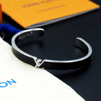 Louis Vuitton cuff bracelet close-up on black enamel band with silver-tone clasp