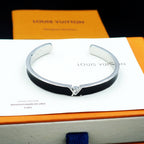 Louis Vuitton cuff bracelet on white insert, black enamel with silver-tone clasp