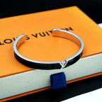 Louis Vuitton cuff bracelet on orange box, black enamel with silver-tone clasp