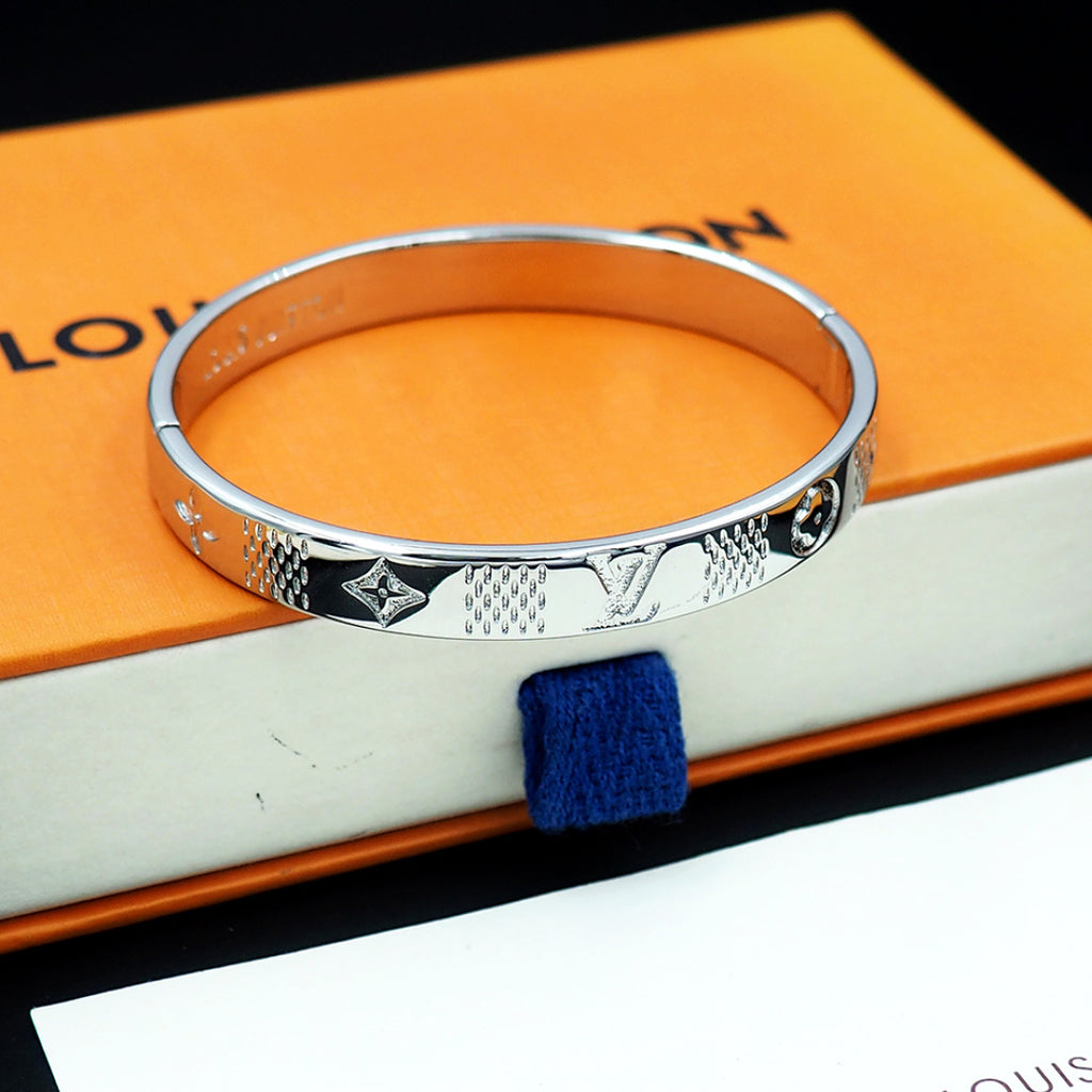 Louis Vuitton engraved silver cuff bracelet with repeating motif band and polished edge