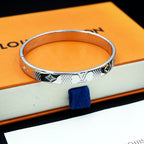 Louis Vuitton engraved silver cuff bracelet with repeating motif band and polished edge