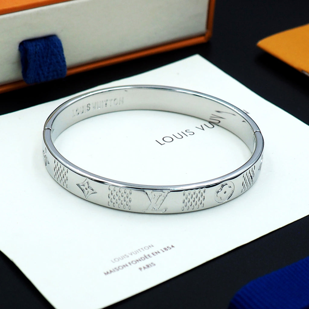 Louis Vuitton engraved silver cuff bracelet viewed from above with inner stamped text