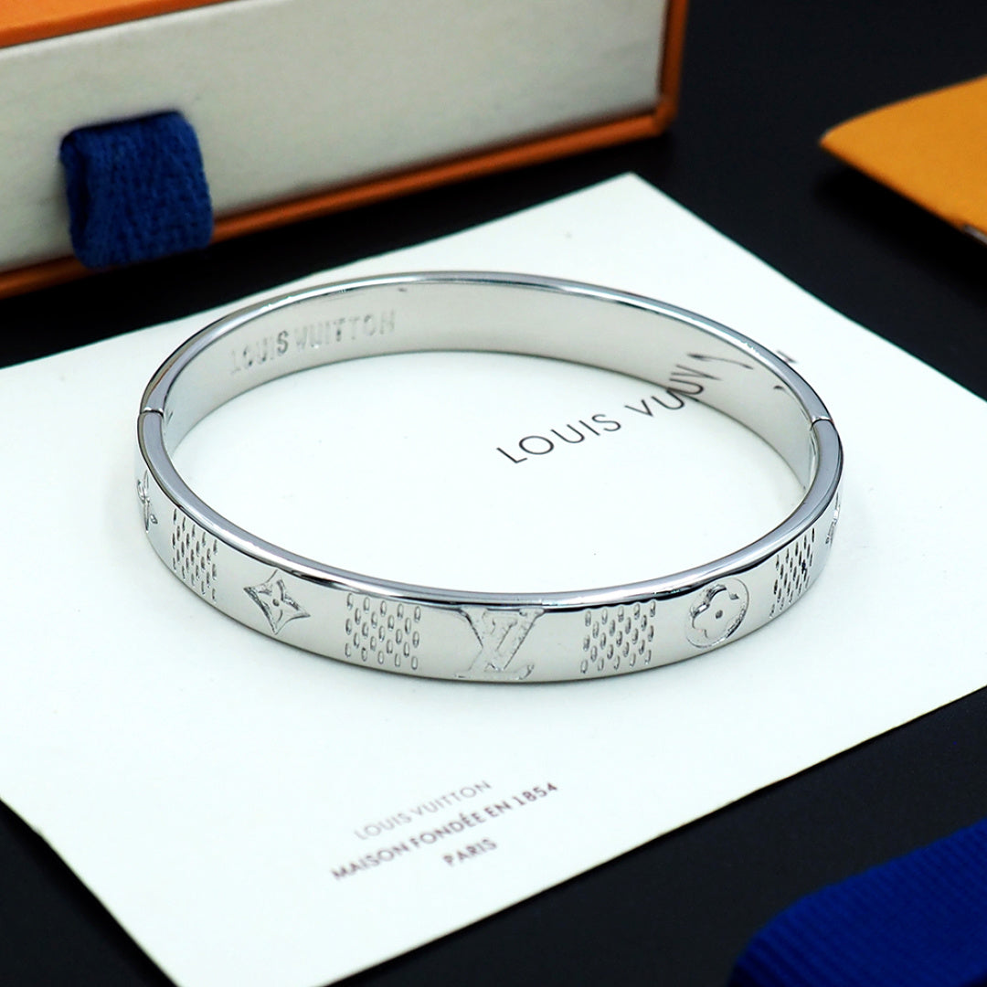 Louis Vuitton engraved silver cuff bracelet viewed from above with inner stamped text