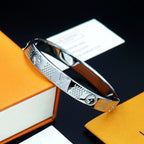 Louis Vuitton hinged engraved silver cuff bracelet with emblem and textured panels