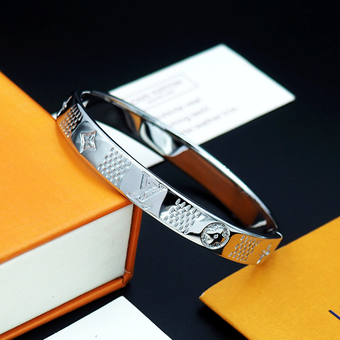 Louis Vuitton hinged engraved silver cuff bracelet with emblem and textured panels
