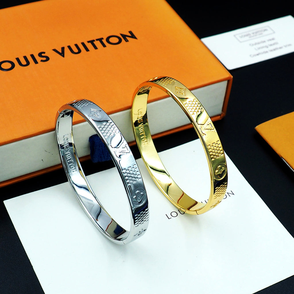 Louis Vuitton metal bangles set in silver and gold with engraved pattern finish