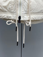 Light beige jacket with dual hood drawstrings and cord toggles