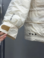 Light beige jacket cuff with embroidered 'DA.NAC' text