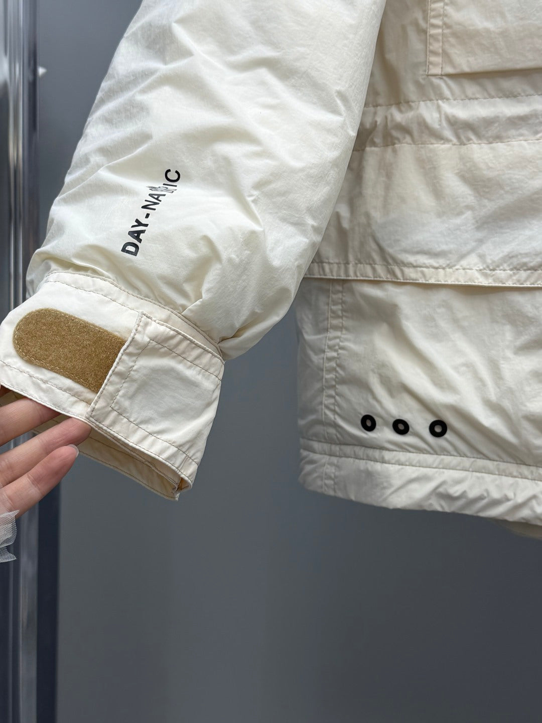 Light beige jacket cuff with embroidered 'DA.NAC' text