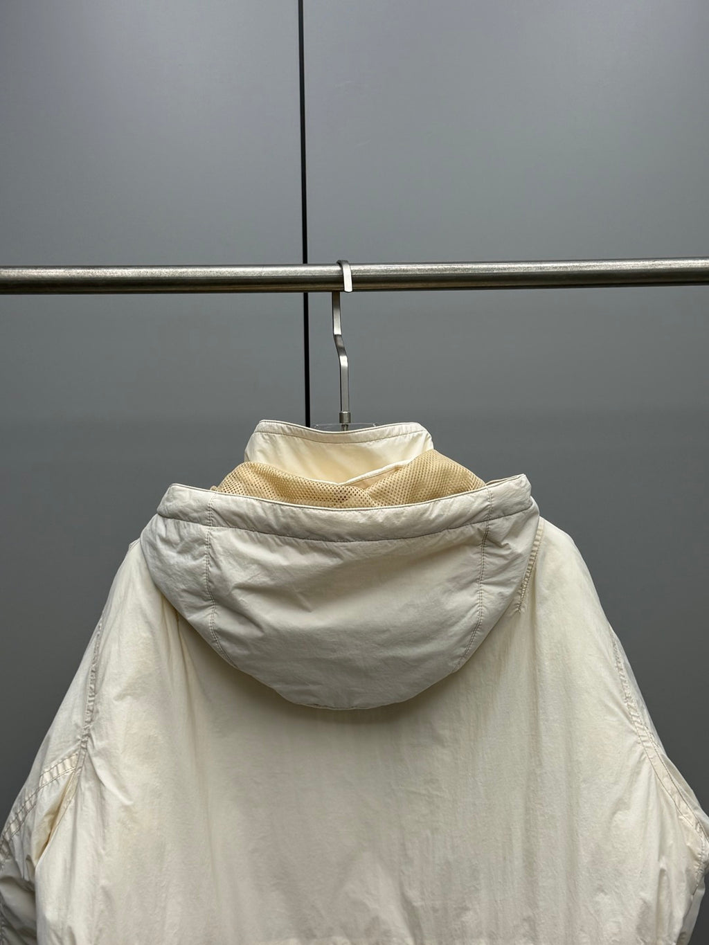 Light beige hooded jacket back view with gathered hood and seam detailing