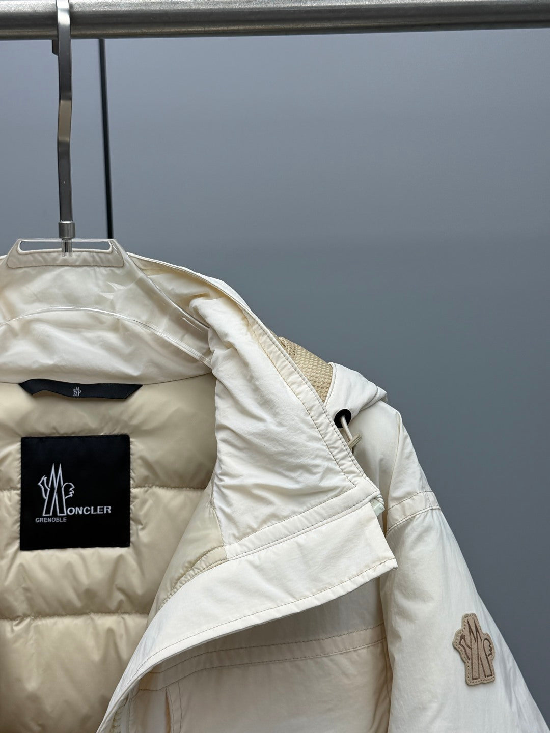 Light beige Moncler jacket with chest logo patch and angled front pocket