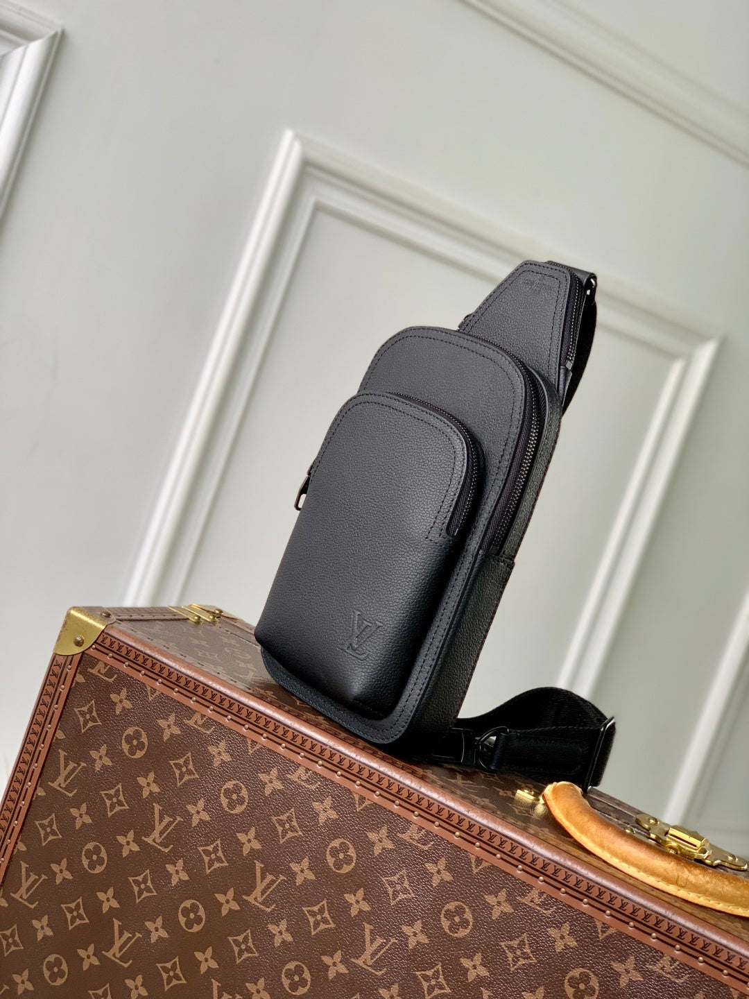 Louis Vuitton dark gray leather crossbody bag on a strap, front zip pocket visible