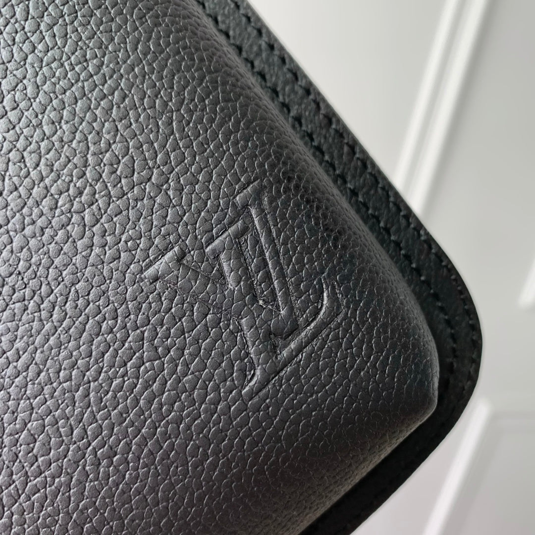 Dark gray pebbled leather corner with stitched edge and embossed logo detail