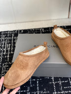 Balenciaga tan suede shearling mules, one shoe held up with pair on box