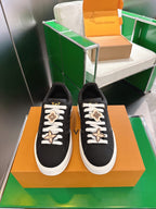 Louis Vuitton low-top sneakers, black canvas with white laces and gold star charm