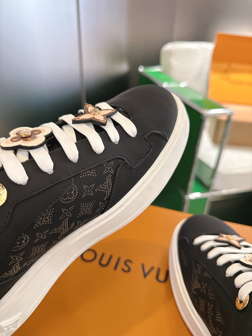 Louis Vuitton sneakers side view, black monogram panel, white laces and gold trim