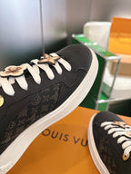 Louis Vuitton sneakers side view, black monogram panel, white laces and gold trim