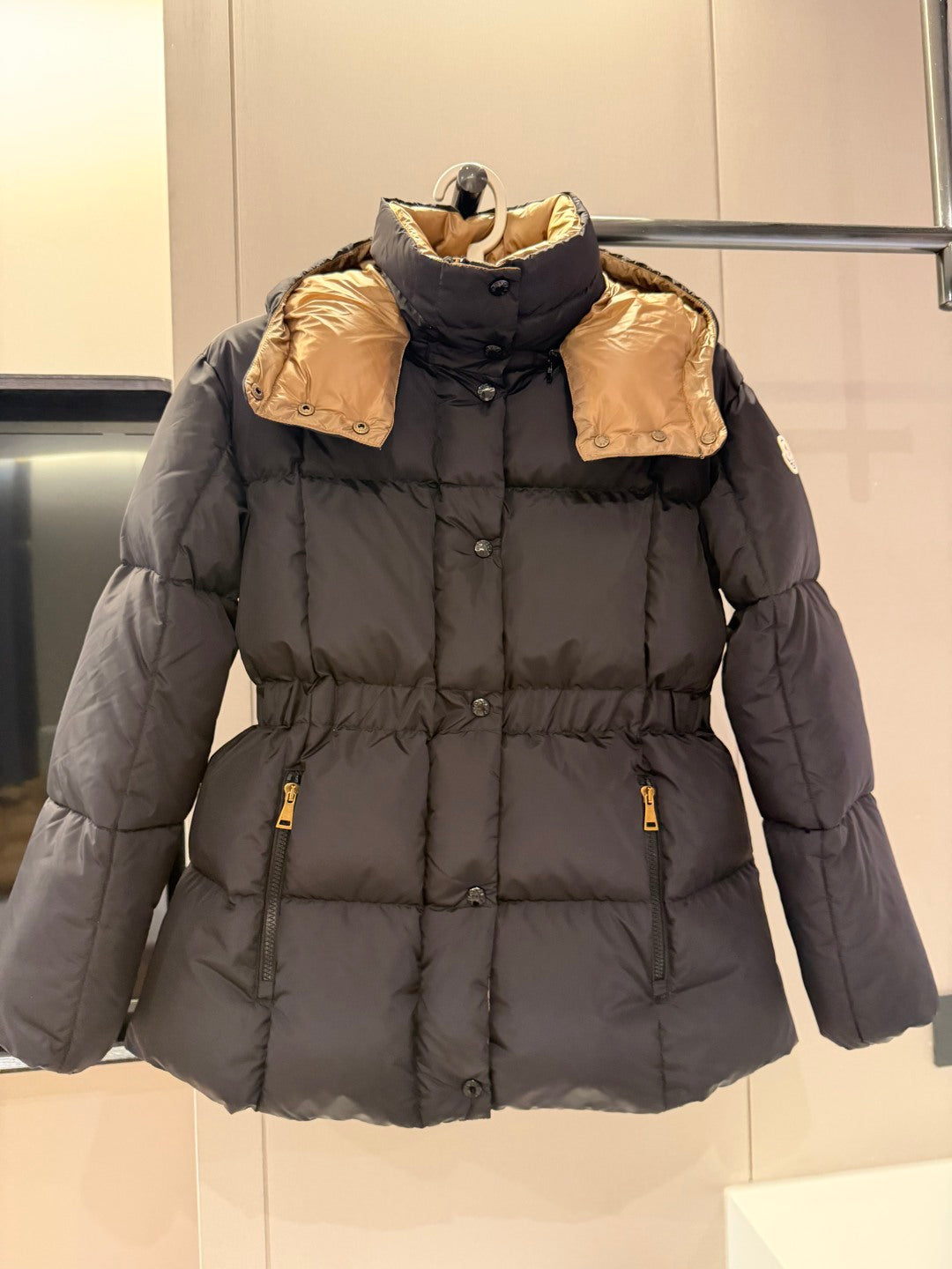 Long dark puffer jacket with hood, front zip, and pocket zips
