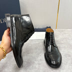 Black leather ankle boots; perforated wingtip side panels and side zipper detail