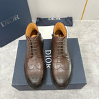 Pair of brown leather lace-up ankle boots with wingtip brogue and black soles.