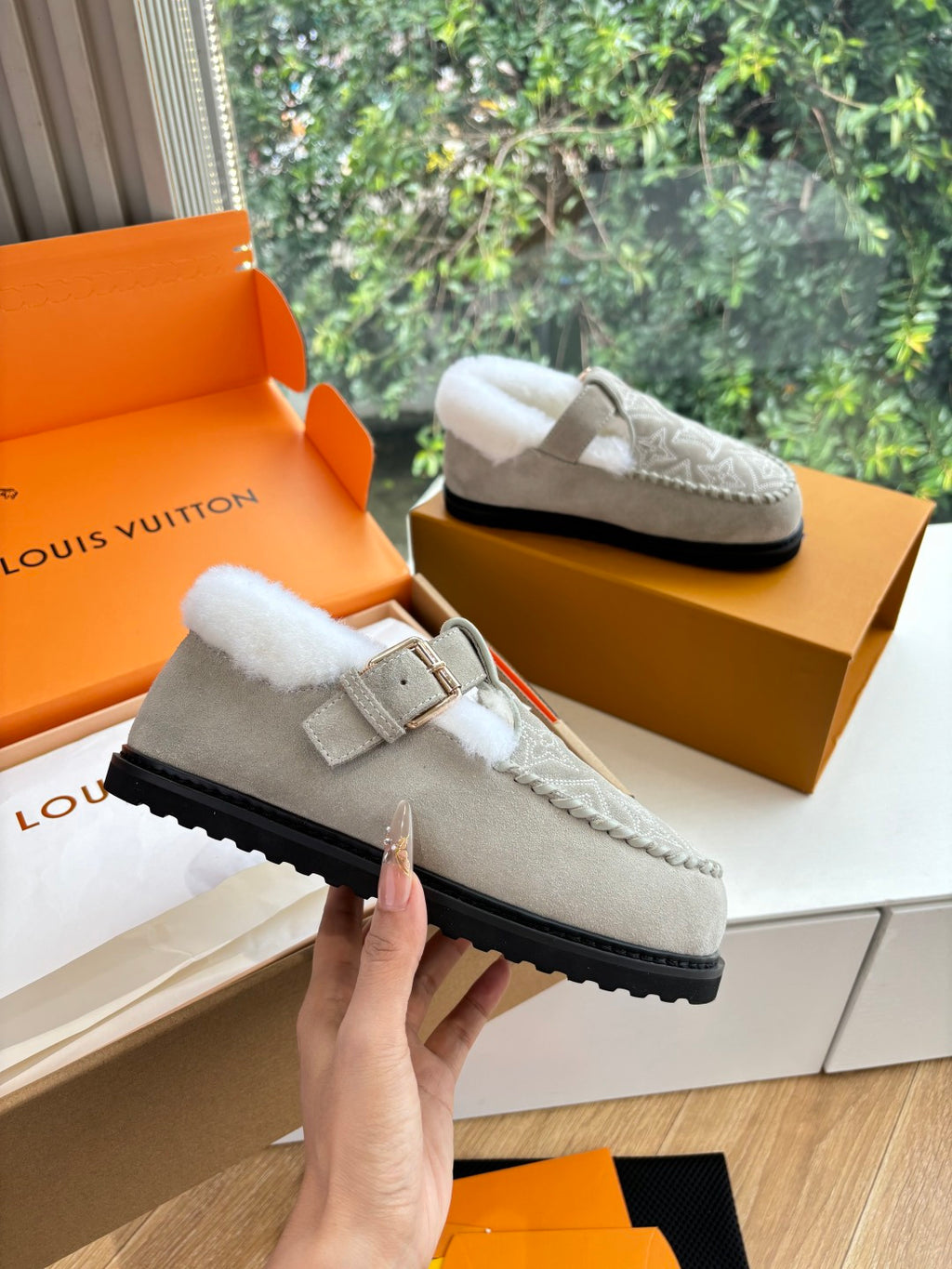 Louis Vuitton unisex suede slip-on shoes with shearling lining and buckle, held in hand