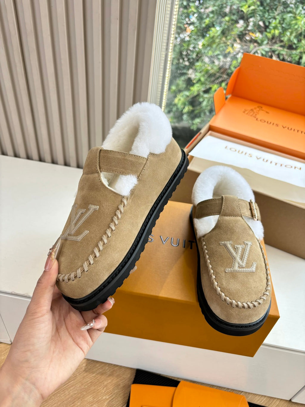 Tan suede shearling moccasin loafer with buckle strap and Louis Vuitton monogram.