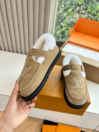 Tan suede shearling moccasin loafer with buckle strap and Louis Vuitton monogram.