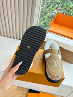 Tan suede moccasin loafer with rubber sole view and buckle strap, Louis Vuitton monogram.