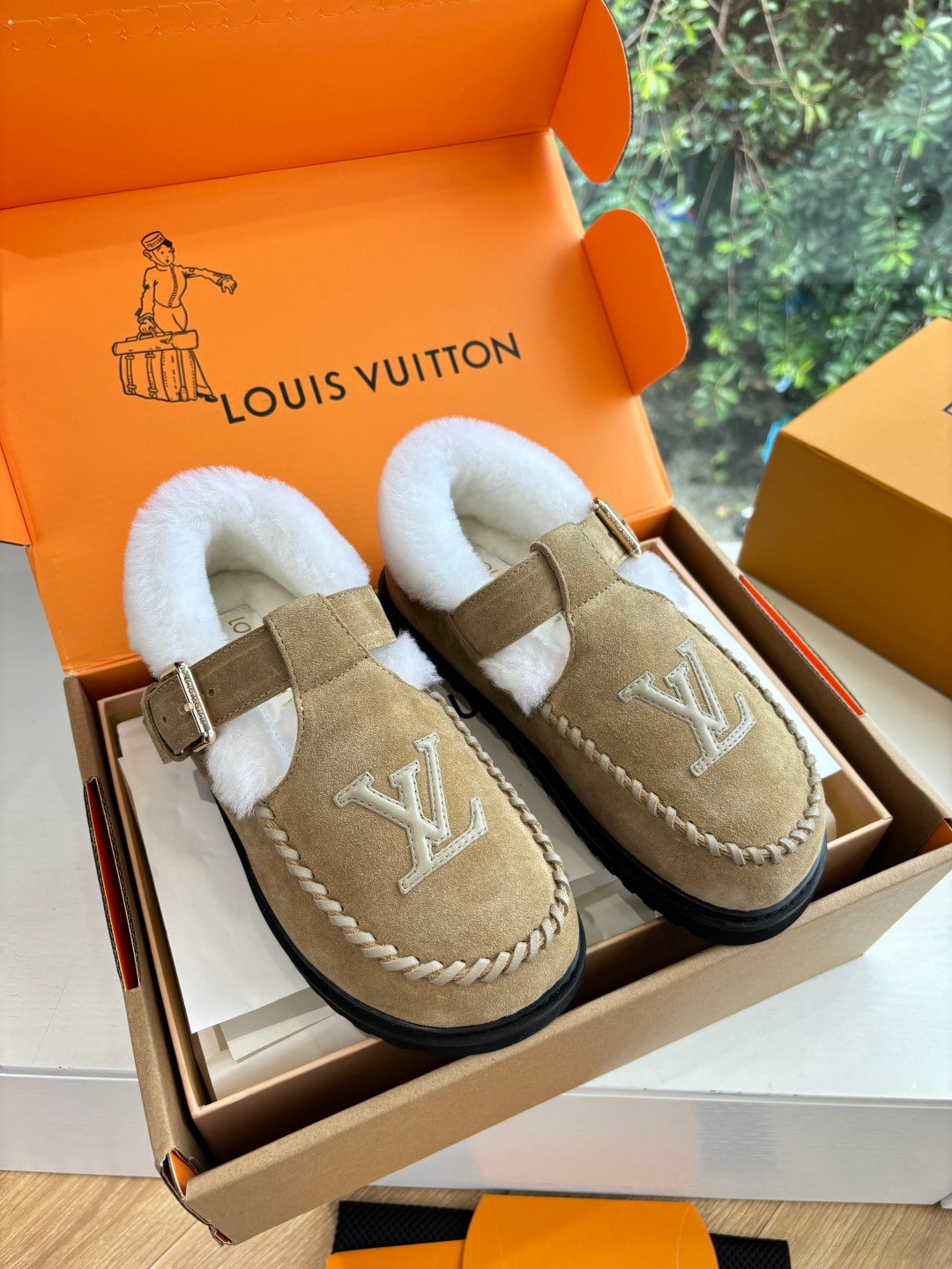 Tan suede shearling moccasin loafers, buckle strap, Louis Vuitton monogram.