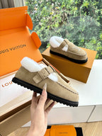 Tan suede shearling-lined loafer with buckle strap and Louis Vuitton monogram.