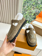 Taupe suede moccasin shoe with white shearling trim, buckle strap, and LV emblem