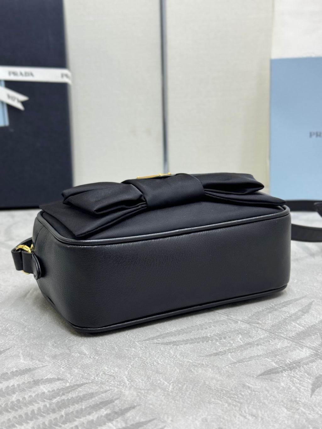Prada crossbody bag backside view, black with stitched folds and top edge