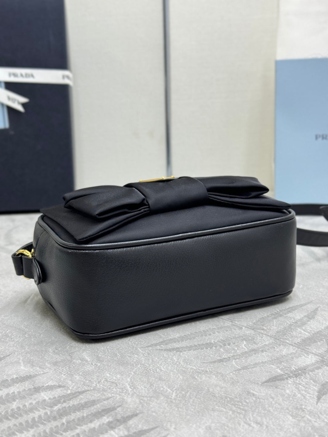 Prada crossbody bag backside view, black with stitched folds and top edge