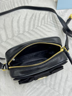 Prada crossbody bag side view with open zipper, black leather and gold trim