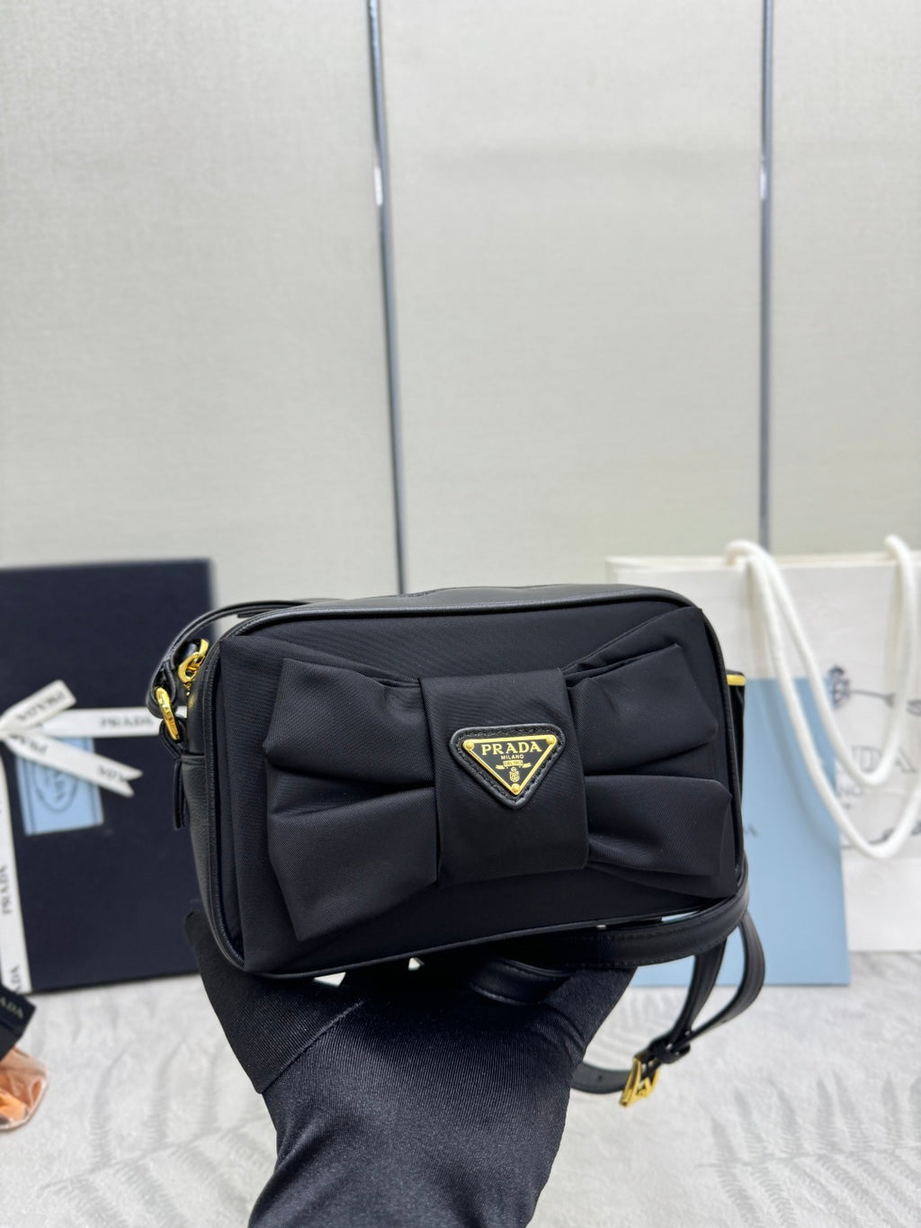Prada crossbody bag side view, black flap with Prada triangular logo