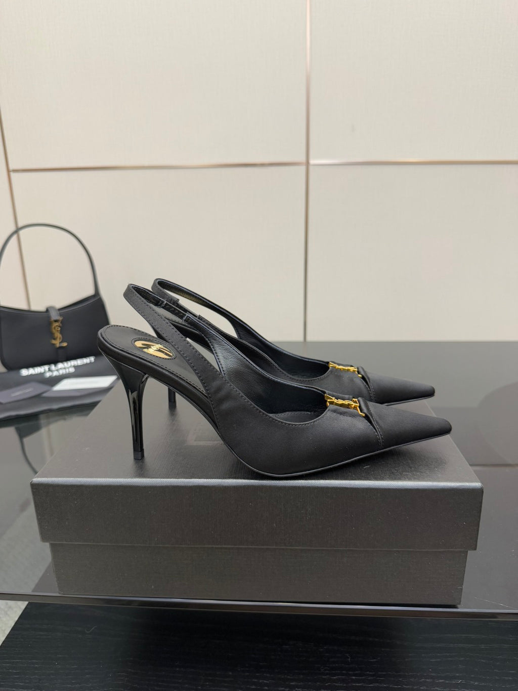 YSL black slingback pumps with stiletto heel and gold logo detail, front angle