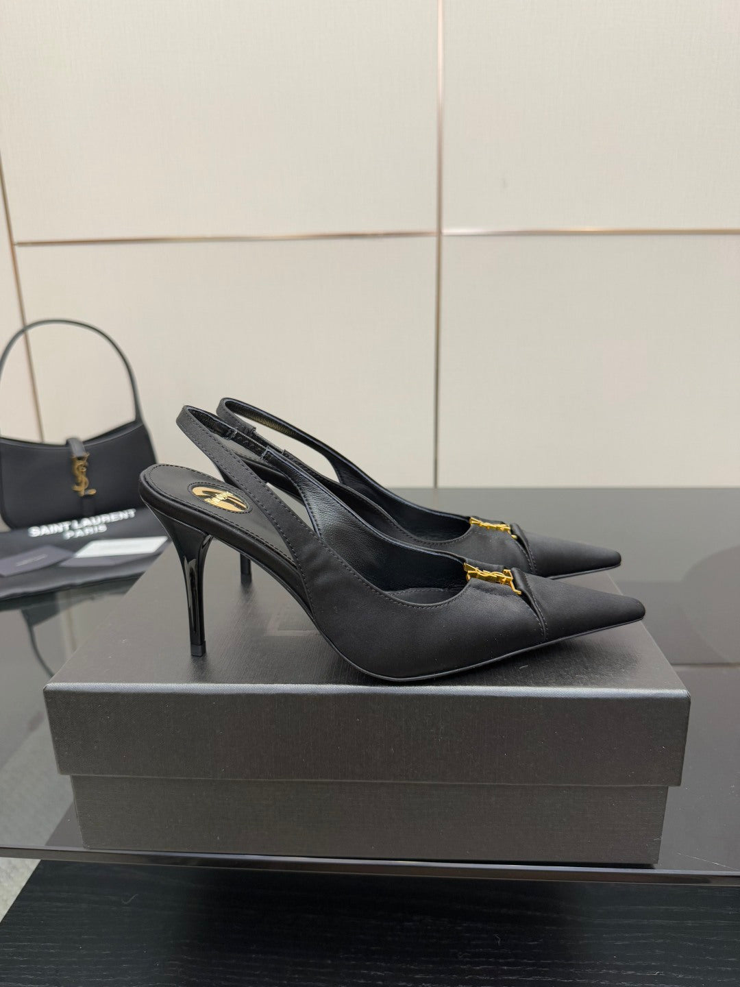 YSL black slingback pumps with stiletto heel and gold logo detail, front angle