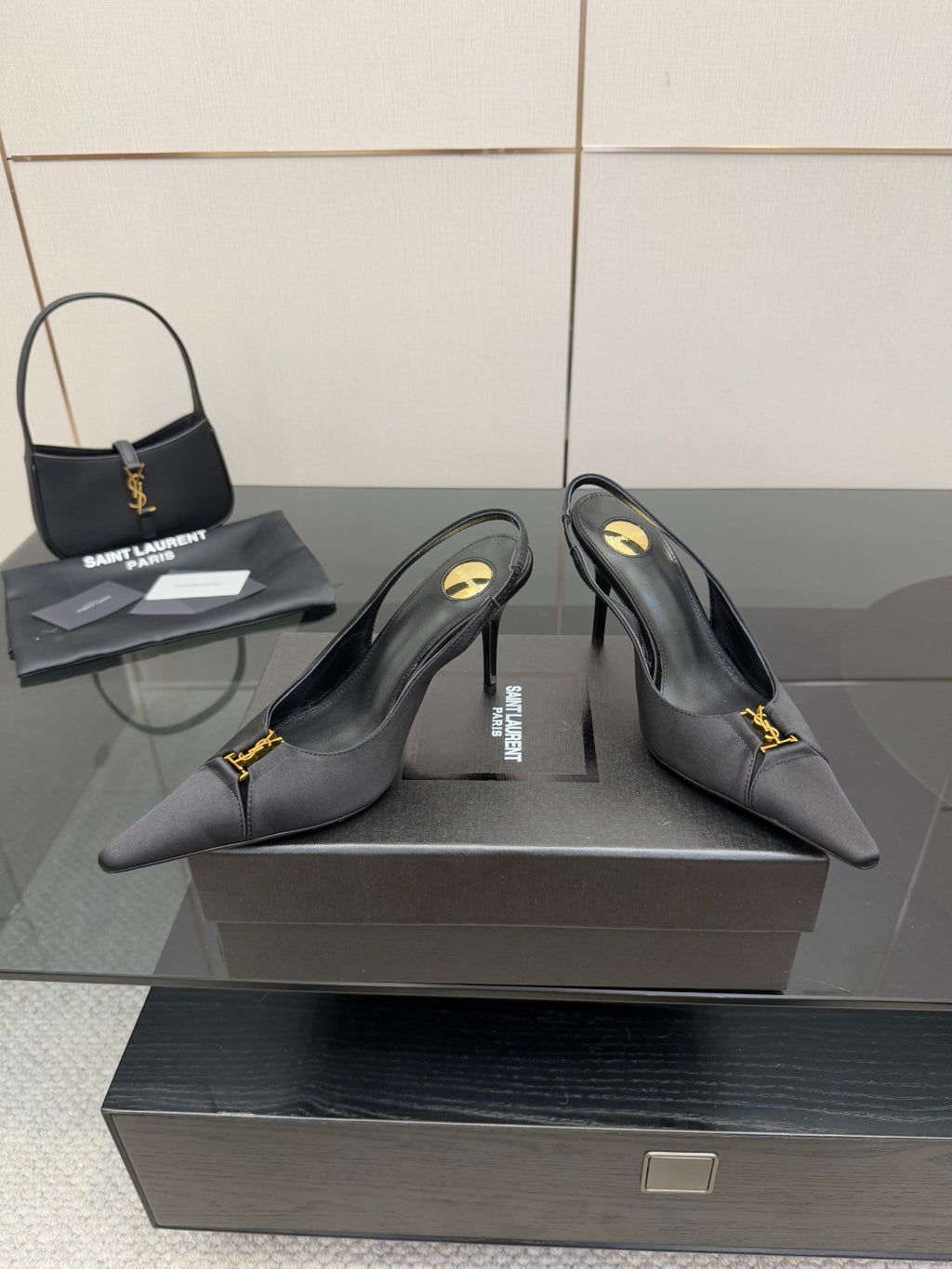 YSL black slingback pumps with pointed toe and gold logo detail, angled view