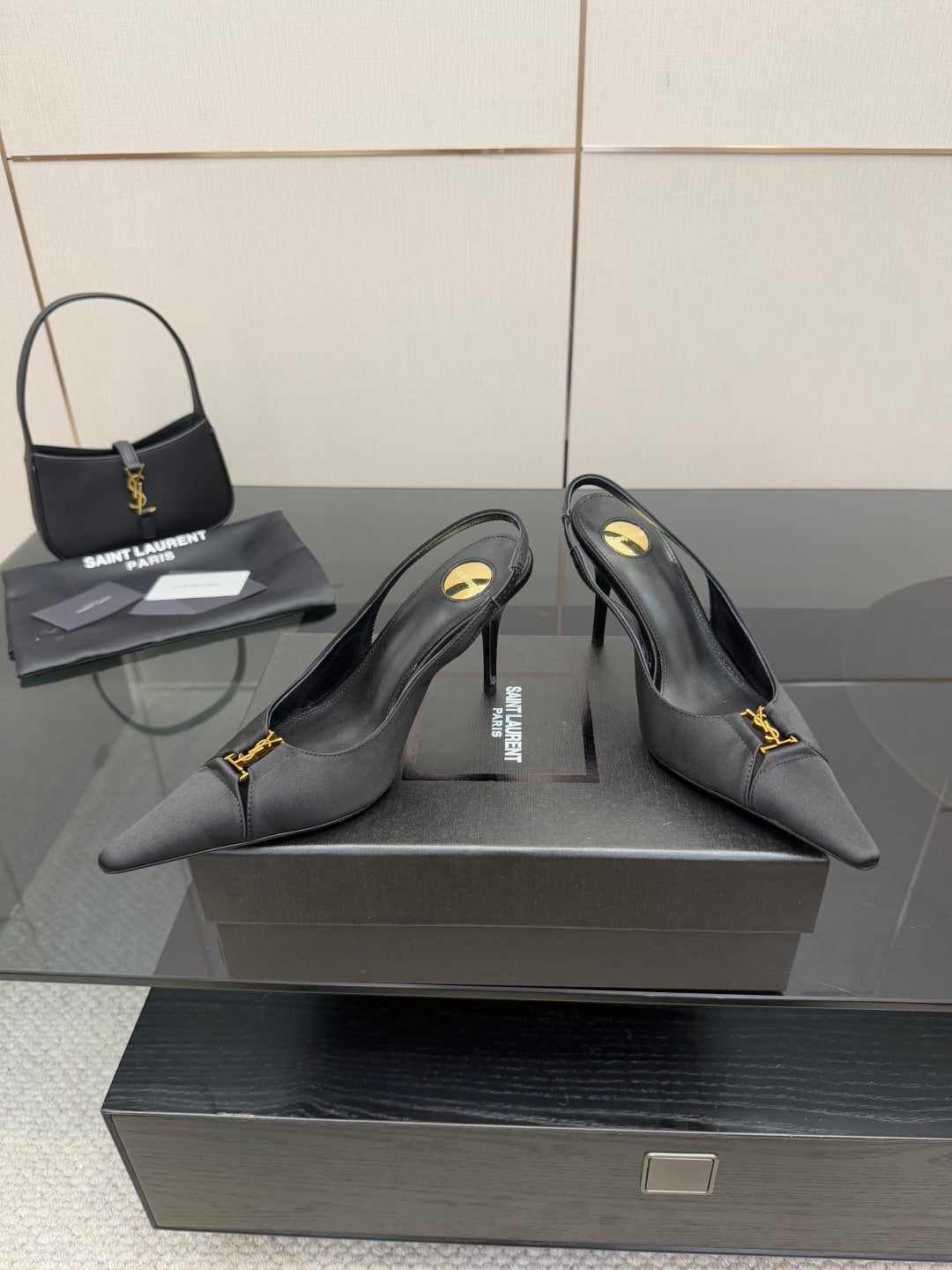 YSL black slingback pumps with pointed toe and gold logo detail, angled view