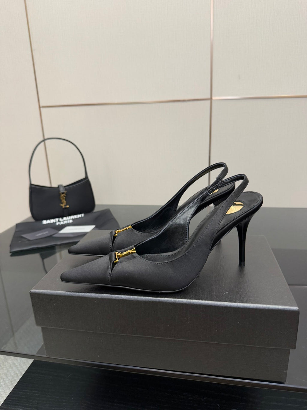 YSL black slingback heeled pumps with gold logo detail, side view