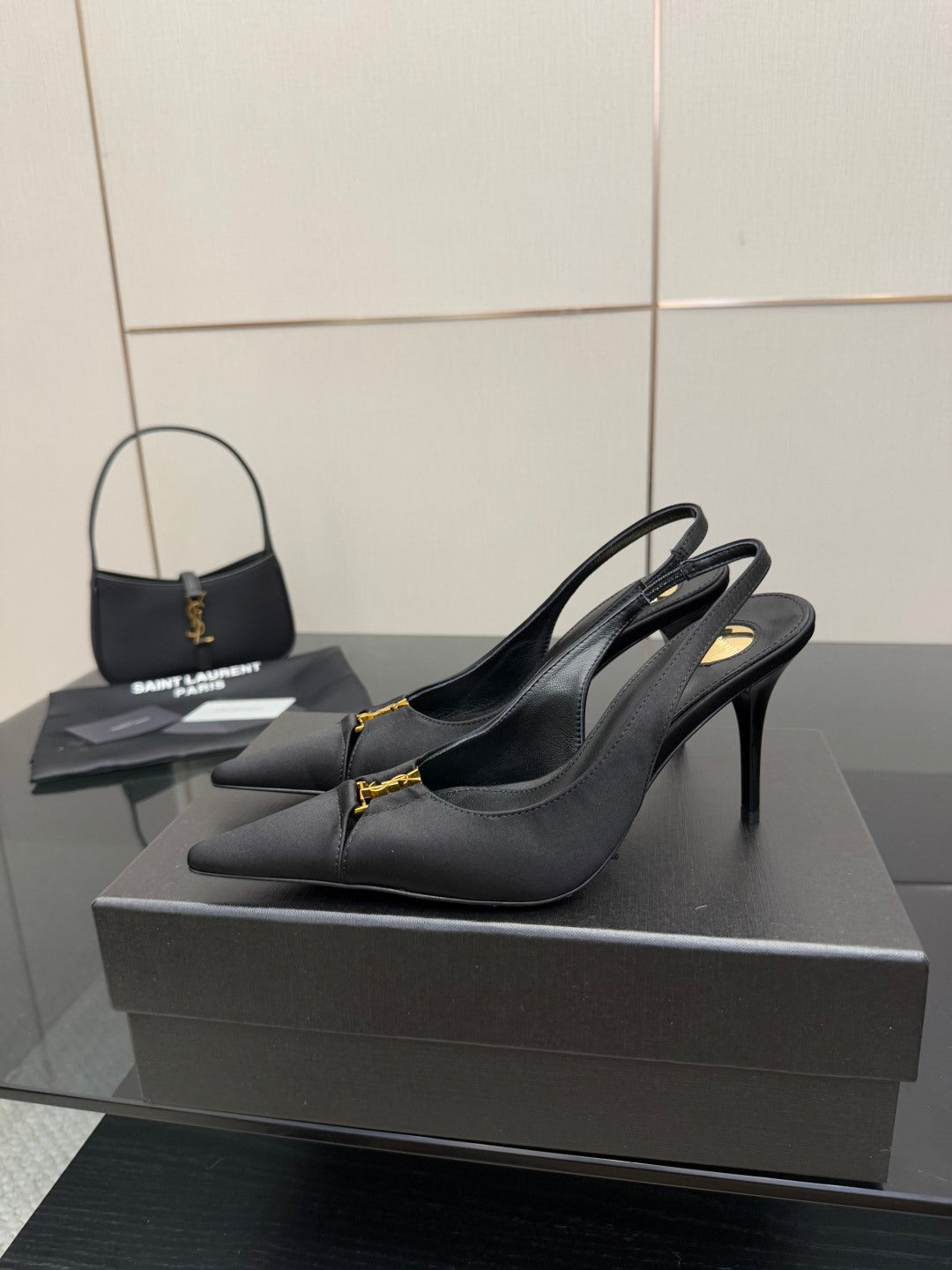 YSL black slingback heeled pumps with gold logo detail, side view