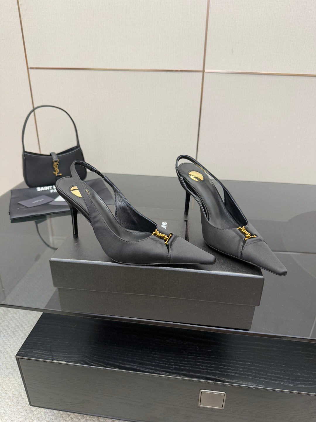 YSL black slingback pumps with gold logo detail, rear angle