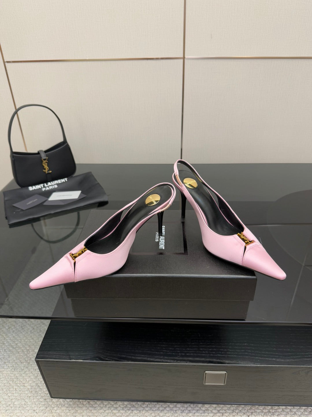 Pink pointed-toe slingback heels with gold buckle on ankle strap