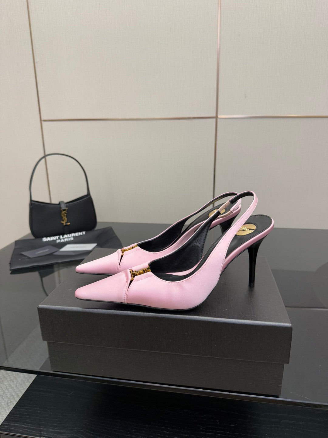Pink leather pointed-toe slingback pumps with black lining and tall stiletto heel