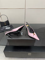 Pink slingback heels with pointed toe, black interior, and gold ankle-buckle detail